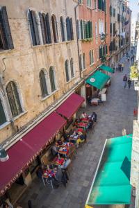 einen Blick über eine Straße mit Tischen und Sonnenschirmen in der Unterkunft A la Pescarìa Studios in Venedig