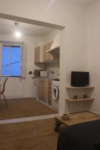 a living room with a television and a kitchen at Nooks Sintra three in Sintra