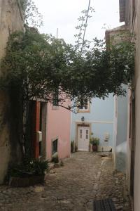 an alley with a tree in the middle of a building at Nooks Sintra three in Sintra