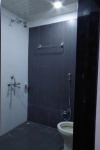 a bathroom with a toilet and a shower stall at Hotel Pariwar in Aurangabad
