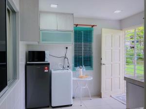 a kitchen with a refrigerator and a small table at Homestay Farah Wangsa Maju KL in Kuala Lumpur