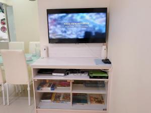 a tv sitting on top of a white entertainment center at Homestay Farah Wangsa Maju KL in Kuala Lumpur