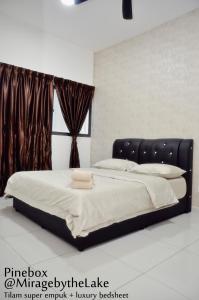 uma cama com uma cabeceira preta num quarto em PineBox Cyberjaya em Cyberjaya