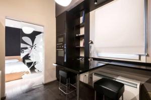 ボローニャにあるDowntown Luxury Apartmentの黒と白のベッドルーム(ベッド1台、デスク付)