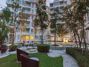 ホアヒンにあるSummer Huahin Condo 2 Bedrooms Pool View Classic Roomの中庭(椅子付)と大きな建物
