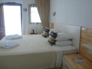 1 dormitorio con 1 cama grande con almohadas y ventana en Dalyan Garden Pension en Dalyan