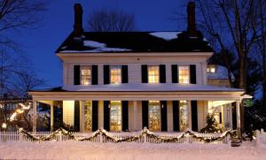 OneSixtyFive, The Inn on Park Row في برونزويك: منزل مغطى بالثلج في الليل مع أضواء عيد الميلاد