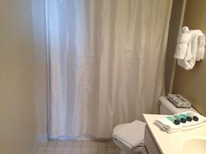a bathroom with a shower with a white shower curtain at National at Ballston Metro in Arlington +16 photos