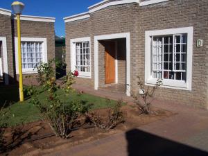 a brick building with white windows and a door at Gables Inn in Colesberg