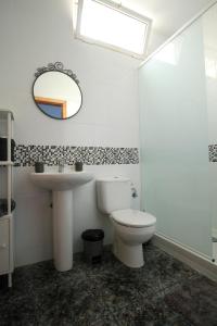 a bathroom with a toilet and a sink and a mirror at Cotillo Sea in Cotillo