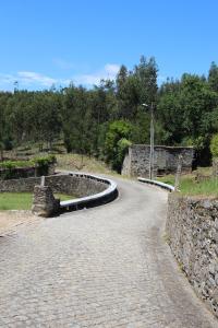 uma estrada sinuosa com uma parede de pedra e árvores em Tapada De Sao Domingos em Gondomar