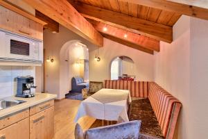a kitchen with a table and a couch in a room at Pension Regina in Lech am Arlberg