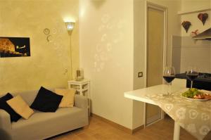 スポレートにあるLe Rose apartment Spoletoのリビングルーム(ソファ、ワイングラス付きのテーブル付)