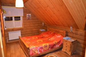 a bedroom with a bed in a wooden room at Guest House Kupechesky in Uglich