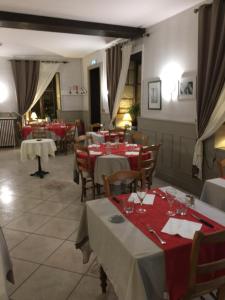 a restaurant with tables and chairs with red tablecloths at Relais de Bèze in Bèze