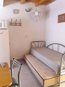 a small room with a bed and a refrigerator at Amaneceres Las Grutas in Las Grutas