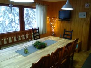 a large wooden table with chairs and a television at Chata pod Brdom in Ružomberok