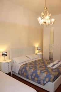 sypialnia z łóżkiem, 2 stołami i żyrandolem w obiekcie Rome Veniero WelcomeHouse w Rzymie