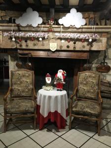 two chairs and a table in front of a fireplace at Relais de Bèze in Bèze