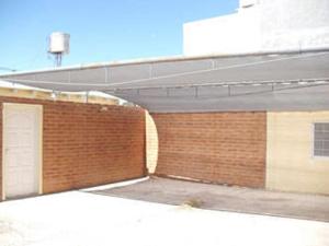 a red brick building with two garage doors on it at Amaneceres Las Grutas in Las Grutas