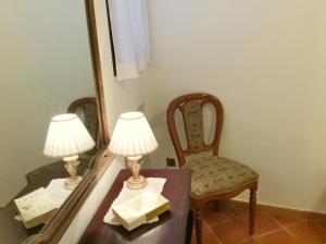 a table with two lamps and a chair next to a mirror at Ca Lucia in Venice