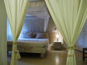 a bedroom with a canopy bed with curtains at Lady D House in Watamu