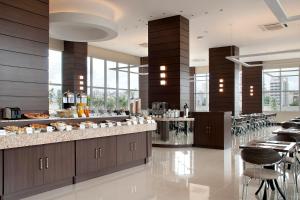 a restaurant with a buffet line with tables and chairs at Master Cosmopolitan Moinhos de Vento in Porto Alegre