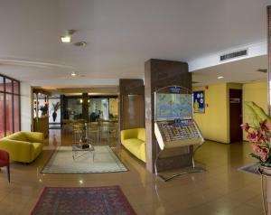 a lobby with a laptop on a display in the middle at Rede Andrade LG Inn in Recife