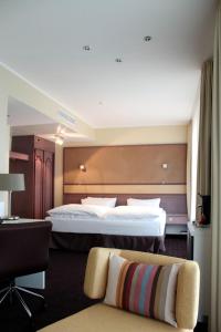 a hotel room with a large bed and a chair at Mercure Hotel Dortmund Centrum in Dortmund
