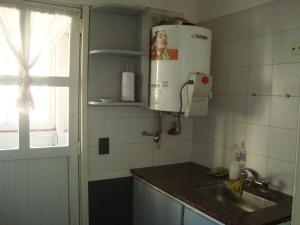 cocina con fregadero y calentador de agua en Departamento Atenas en Mar del Plata