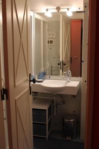 un baño con lavabo y espejo en Rose's House, en Costa da Caparica 21 fotos más