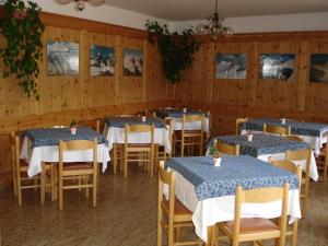 a dining room with tables and chairs and wooden walls at Albergo - B&B Alpina in Valdidentro