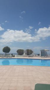 a large swimming pool with a tile floor and blue sky at Apartamentos Carlota in Puerto del Carmen