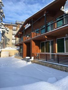 a building with snow on the ground in front of it at Chalet Kokhta in Bakuriani