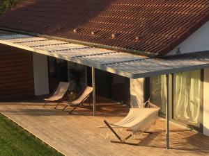 two chairs sitting on a deck next to a house at Ferienhaus mit Sonnendeck in Sankt Wendel