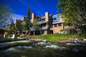 a house with a river in front of a building at River Mountain Lodge by Breckenridge Hospitality in Breckenridge