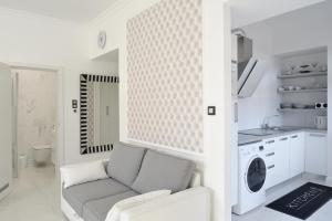 a white living room with a couch and a kitchen at Apartment Sloapart in Rogaška Slatina