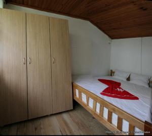 a bedroom with a bed with a red blanket on it at Bujtina Zhaveli in Gjakove