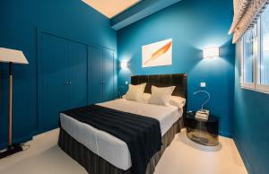 マドリードにあるPlaza Santa Anaの青い壁のベッドルーム1室、ベッド1台(白いシーツ付)