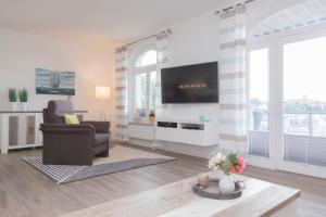 sala de estar con silla y TV en Stadtvilla mit Hafenpanorama en Flensburg