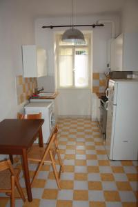Il comprend une cuisine équipée d'une table, d'un réfrigérateur, d'une table et de chaises. dans l'établissement Andrea e Valentina, à Trieste