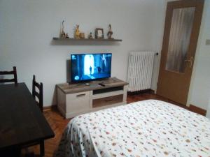 una camera da letto con un televisore su un comò con un letto di Andrea e Valentina a Trieste