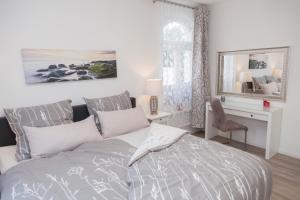 Un dormitorio con una cama y un escritorio con espejo. en Stadtvilla mit Hafenpanorama, en Flensburg