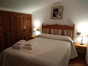 カソルラにあるApartamentos Asador De La Plaza Viejaのベッドルーム1室(ベッド1台、タオル2枚付)