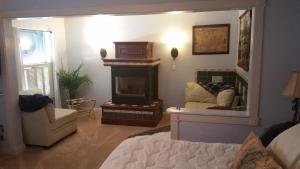 a bedroom with a fireplace and a bed and a mirror at Woodstock Inn Bed & Breakfast in Independence