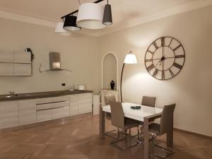 cocina con mesa y reloj en la pared en GIURIA 35 - Elegante ed accogliente nei pressi del Valentino en Turín