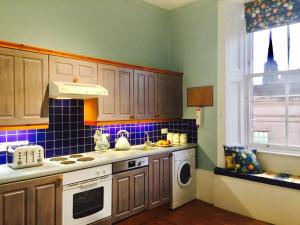 a kitchen with a stove top oven next to a window at Royal Mile St Giles St in Edinburgh