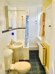 Baño blanco con aseo y lavamanos en Royal Mile St Giles St, en Edimburgo