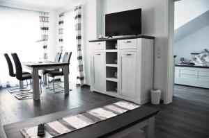 a living room with a tv and a table with chairs at FW-Siegel in Singen