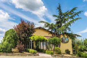 Una casa amarilla con un árbol delante. en Locanda San Giorgio, en Sestola